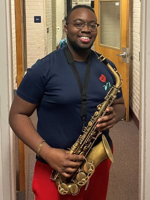 Pierre Baldwin, a talented student at Pensacola State College, proudly displays his saxophone after.