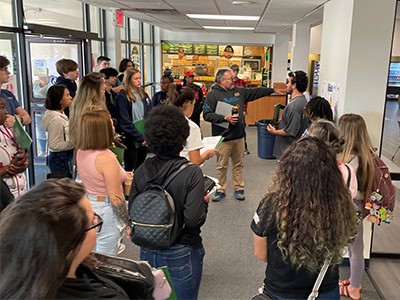 Diverse group of students walking through Pensacola State College campus during orientation event.