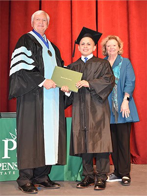 Graduating adult education student receiving diploma at Pensacola State College.