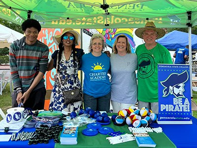 High school students and community leaders at Pensacola State College booth during Juneteenth festiv.