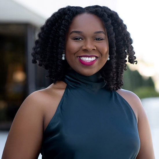 Diverse student smiling outdoors at Pensacola State College campus.