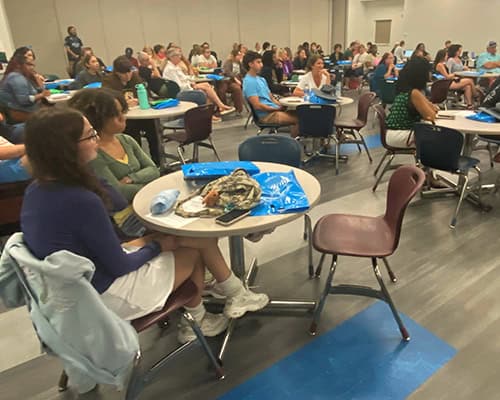 Students attending New Student Orientation in a large classroom setting.