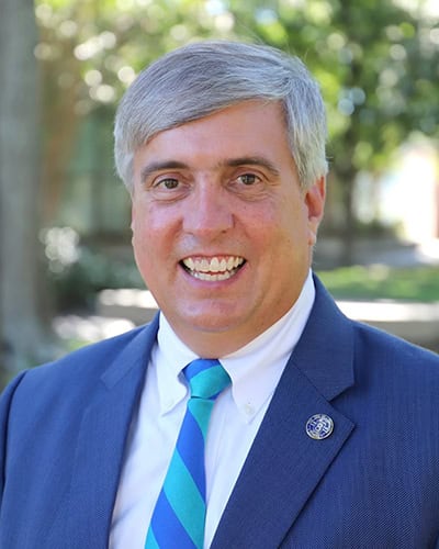 High-resolution image of Grover Robinson IV, a prominent figure in higher education, smiling outdoor.