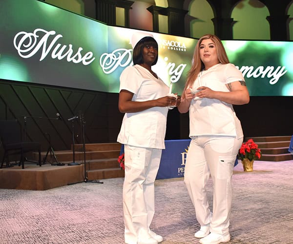Nurse pinning ceremony honoring veterans transitioning to nursing careers at Pensacola State College.