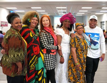 Diverse group of people celebrating Black History Month at Pensacola State College event.