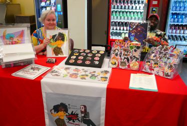 Diverse individuals showcase vibrant artwork honoring Black culture and history.