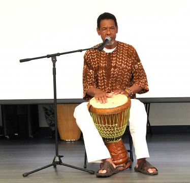 African American musician playing djembe drum during Black History Month event at Pensacola State Co.