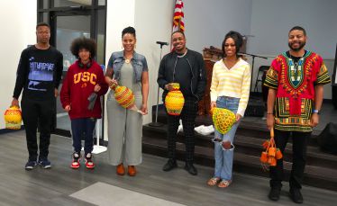 Diverse group of students and faculty holding colorful African baskets during Black History Month ev.