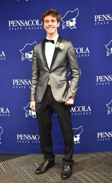 Young man in formal tuxedo at college event.