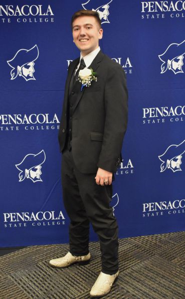 Young man in a suit at Pensacola State College graduation event.