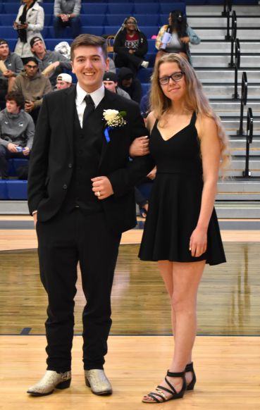 Young man and woman in formal attire at graduation event.
