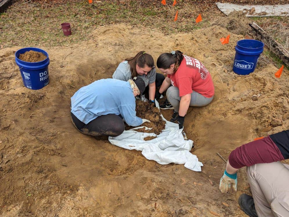 Field 2: Forensic science students at Pensacola State College analyzing pig carcass during annual fo.