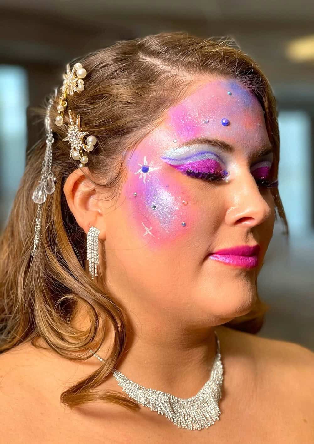 Cosmetology student showcasing intricate, colorful makeup artistry at Pensacola State College.