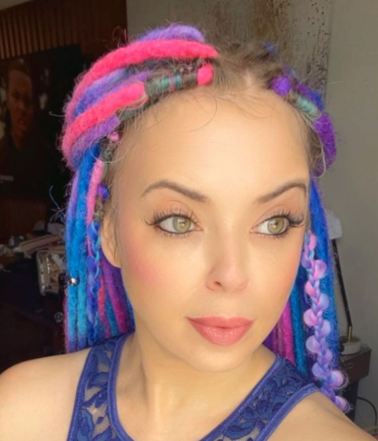 Beautiful cosmetology graduate with colorful dreadlocks at The Skin Games competition.