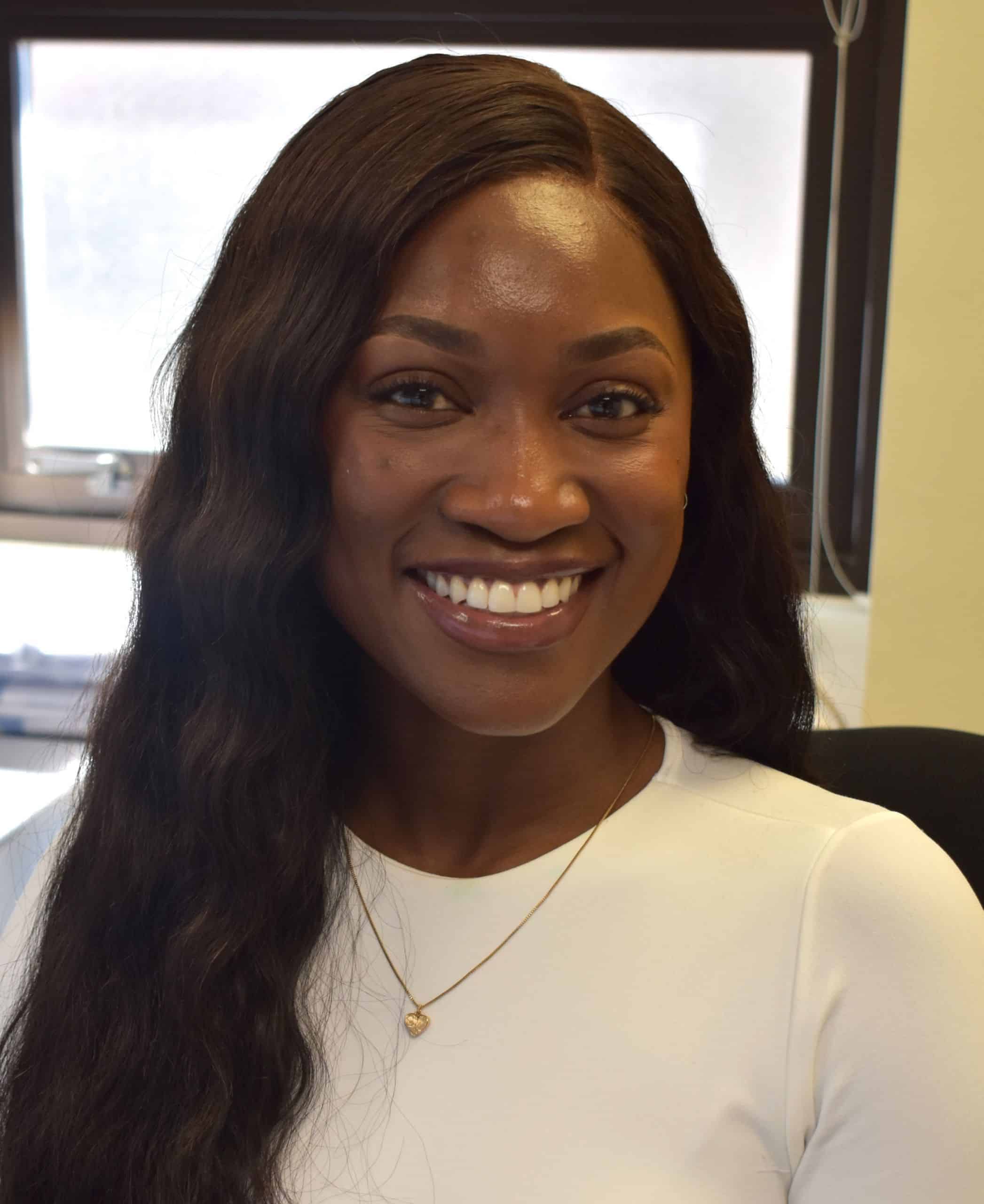 Diverse student smiling at campus, highlighting military-friendly education excellence.