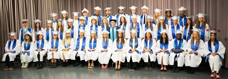 Celebrating 44 seniors graduating from PSC Charter Academy in caps and gowns.