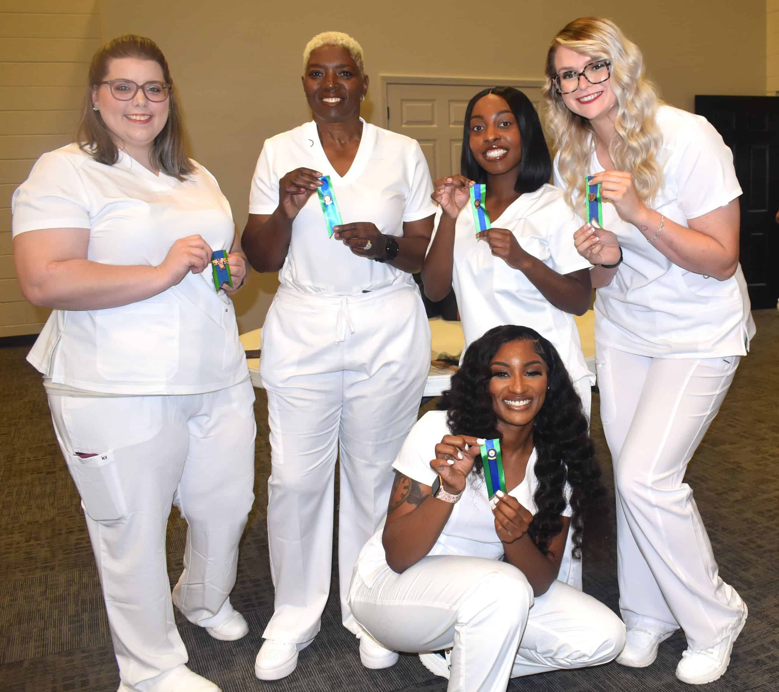 Nursing students proudly display their pins at the graduation ceremony.