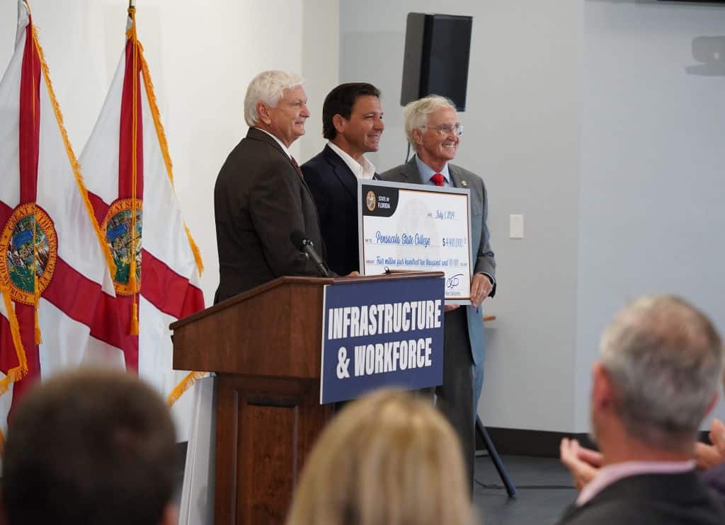High-resolution image of Pensacola State officials receiving a $4.41 million grant for aviation airf.