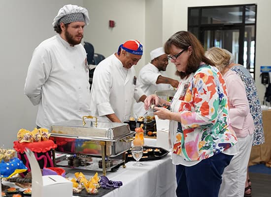 Supporters at Pensacola State enjoy a grazing, grapes, and grain reception during the event.