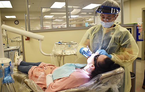 Dental hygiene student practicing oral care techniques on patient in clinical training at Pensacola.