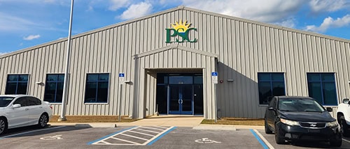 Modern college campus building with accessible parking and clear signage at Pensacola State College.