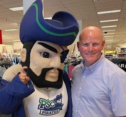 Pirate mascot and man smiling at Pensacola State College event promoting educational opportunities.