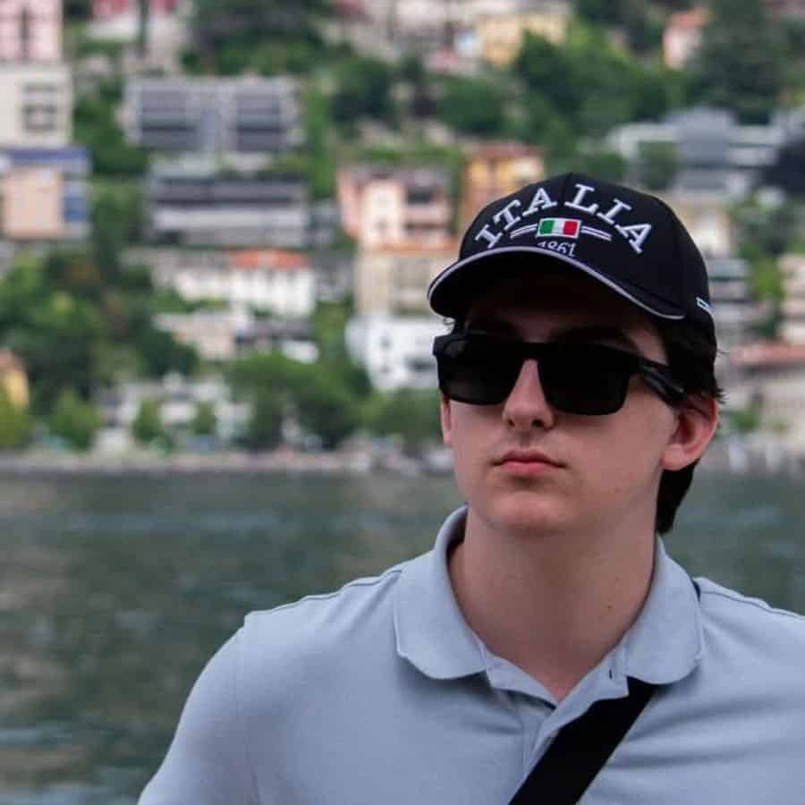 Young man wearing "Vita Lait" cap and sunglasses during Fall 2024 graduation event.