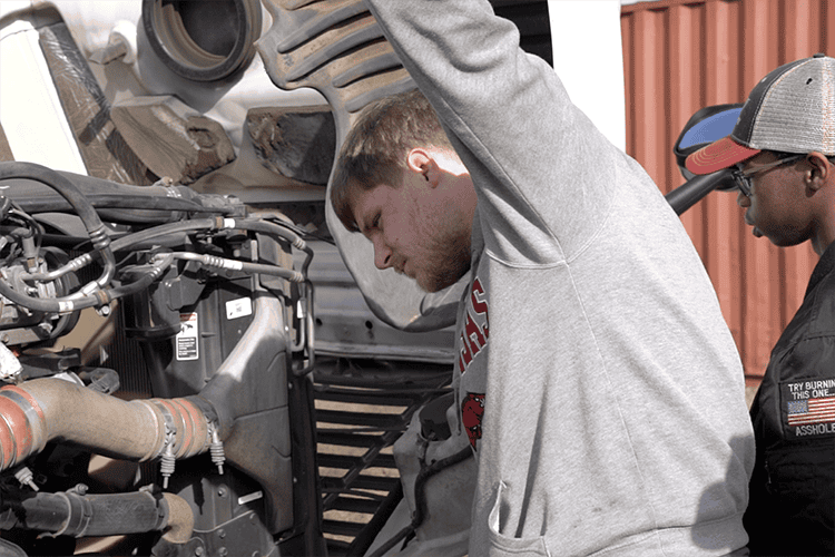 High school students learning diesel engine repair for ASE certification.