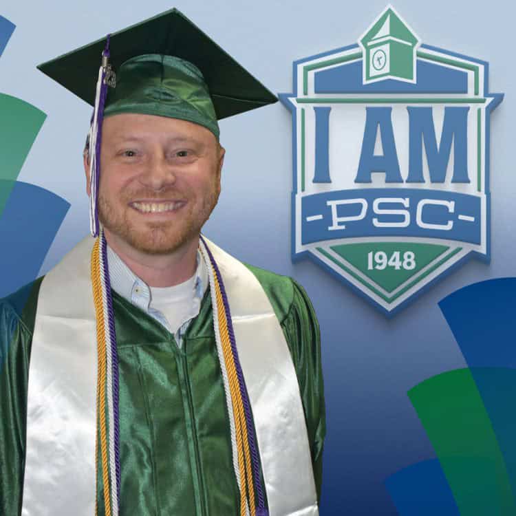 Smiling graduate in cap and gown at PSC graduation ceremony.